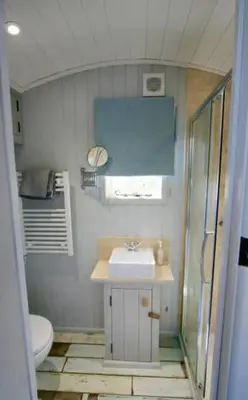 a small bathroom with a sink and a toilet at Shepherd's Hut Gorran Haven Panoramic Ocean Views in Gorran Haven