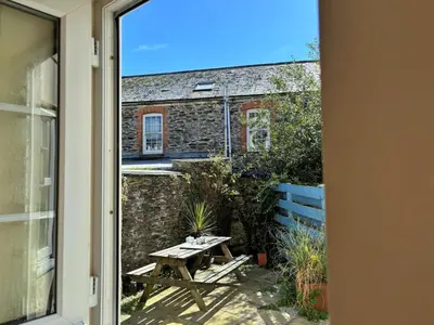 a patio with a picnic table and a building at Holiday Home Porthilly by Interhome in Mevagissey