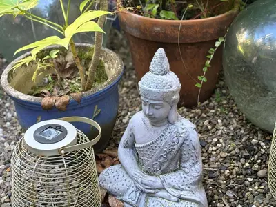 a statue sitting on the ground next to plants at Holiday Home Porthilly by Interhome in Mevagissey