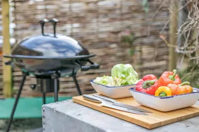 a grill and two bowls of vegetables on a table at 1 Bed in Menheniot oc-t29268 in Menheniot