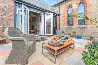 a patio with wicker chairs and a table with fruit on it at 1 Bed in Menheniot oc-t29268 in Menheniot