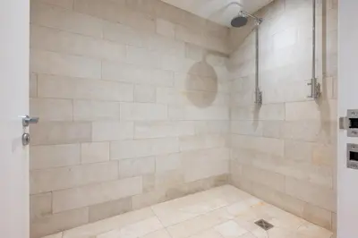a bathroom with a shower with a tiled wall at 5 Bed in Polzeath oc-r33648 in Polzeath