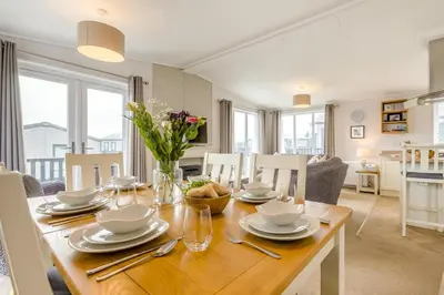 a dining room and living room with a wooden table at 3 Bed in Padstow oc-l33613 in Padstow