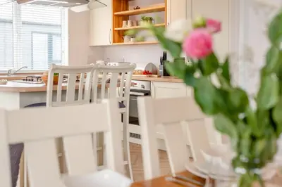 a kitchen with white chairs and a table with a vase of flowers at 3 Bed in Padstow oc-l33613 in Padstow