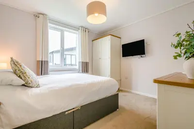 a bedroom with a large bed and a tv at 3 Bed in Padstow oc-l33613 in Padstow