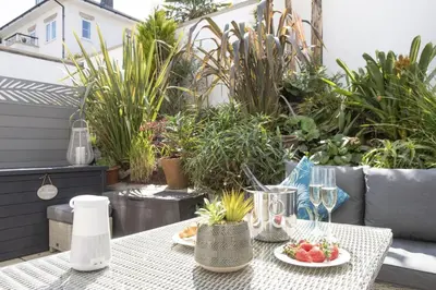 a table with a plate of food on a patio at Crystal View, Compass Point - Sea View - Free WiFi & Parking - Close to Beach in Carbis Bay