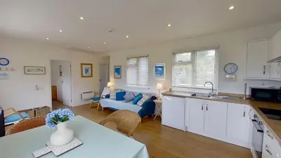 a kitchen and living room with a blue couch at G24 Trelinda, Riviere Towans in Hayle
