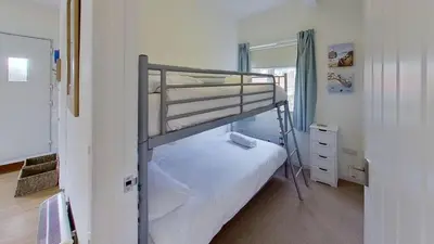 a bedroom with two bunk beds and a mirror at G24 Trelinda, Riviere Towans in Hayle