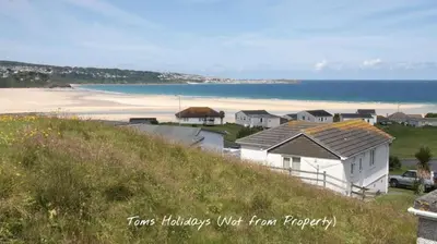 a house on a hill next to a beach at G24 Trelinda, Riviere Towans in Hayle