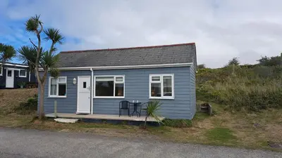 a small blue house with a table on a porch at G24 Trelinda, Riviere Towans in Hayle