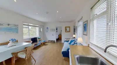 a kitchen and living room with a sink and a couch at G24 Trelinda, Riviere Towans in Hayle