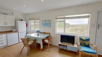 a kitchen with a table and a tv and a table and chairs at G24 Trelinda, Riviere Towans in Hayle