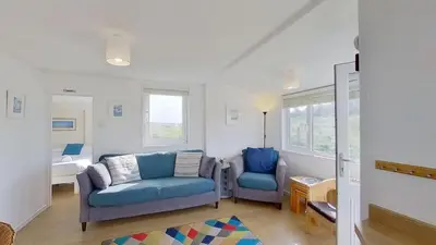 a living room with two chairs and a couch at G22 Happy Days, Riviere Towans in Hayle