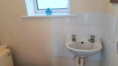 a white sink in a bathroom with a window at G22 Happy Days, Riviere Towans in Hayle