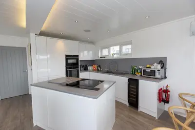 a kitchen with white cabinets and a counter top at Dahlia in Redruth