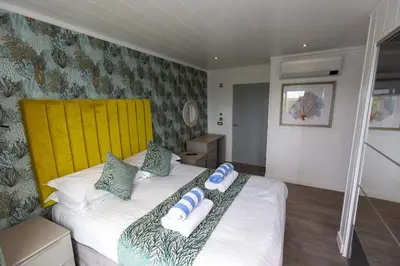 a bedroom with a bed with a yellow headboard at Dahlia in Redruth