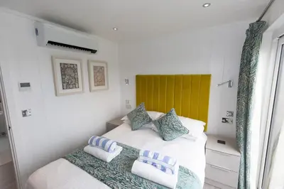 a bedroom with a bed with blue and white pillows at Dahlia in Redruth