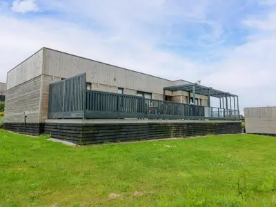 a building with a grass field in front of it at Dahlia in Redruth