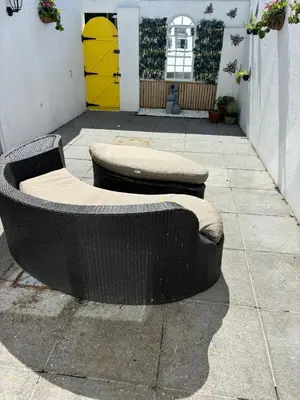 two wicker benches sitting on a sidewalk in front of a building at Num 29 in Newquay