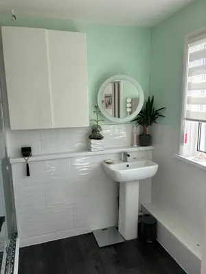 a white bathroom with a sink and a mirror at Num 29 in Newquay