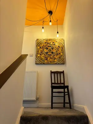 a stairway with a chair and a painting on the wall at Num 29 in Newquay
