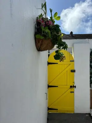 a yellow door with a potted plant on a building at Num 29 in Newquay