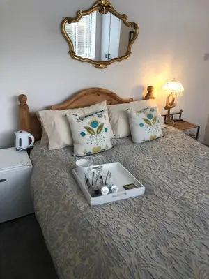 a bed with a tray with glasses on it at Num 29 in Newquay