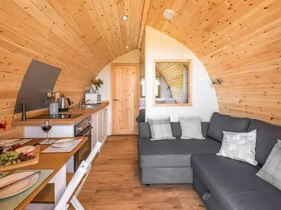 a living room with a couch and a kitchen at Scenic Bay in Penzance