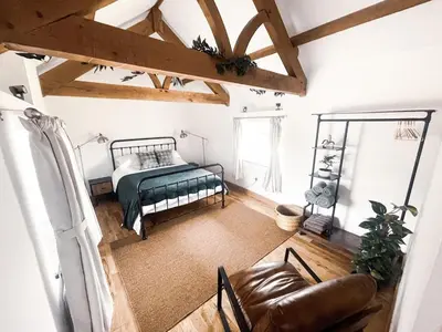 a bedroom with a bed and a couch in a room at The Retreat Cornwall holiday home with hot tub in Crowan
