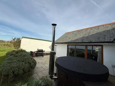 a house with a grill in front of it at The Retreat Cornwall holiday home with hot tub in Crowan