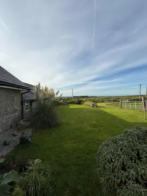 a yard with a house and a field of grass at The Retreat Cornwall holiday home with hot tub in Crowan