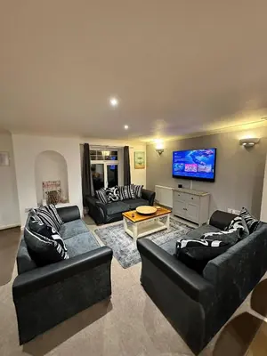 a living room with two couches and a flat screen tv at Dog Friendly Holiday Home in Newquay Cornwall in Newquay
