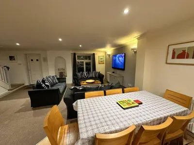 a living room with a table and a couch at Dog Friendly Holiday Home in Newquay Cornwall in Newquay