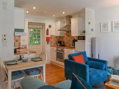 a kitchen with a blue couch and a blue chair at Kingfisher Cottage, 20 in Camelford