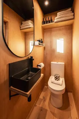 a bathroom with a black sink and a toilet at Cabins at Bogee Farm in Saint Ervan