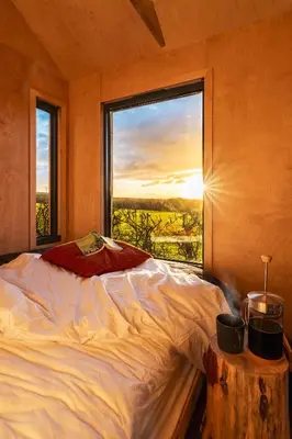 a bedroom with a bed and a large window at Cabins at Bogee Farm in Saint Ervan