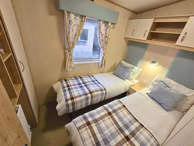 a small room with two beds and a window at Cornish Dream in Truro