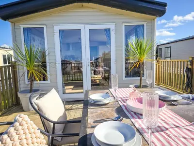 a patio with a table and chairs on a deck at Cornish Dream in Truro