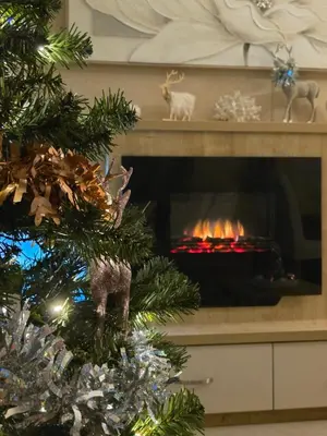 a christmas tree in front of a fireplace at Cornish Dream in Truro