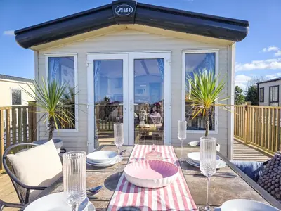a patio with a table with plates and glasses at Cornish Dream in Truro