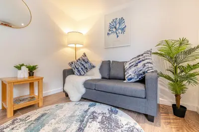 a living room with a couch and a plant at Landal Leycroft Valley in Perranzabuloe