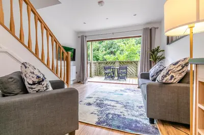 a living room with two couches and a staircase at Landal Leycroft Valley in Perranzabuloe