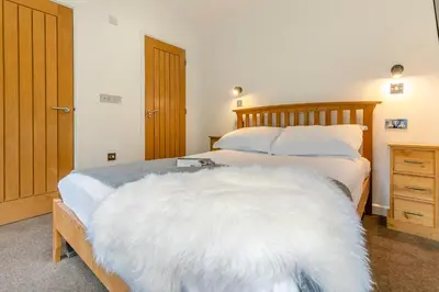 a bedroom with a bed with a white blanket on it at Landal Leycroft Valley in Perranzabuloe