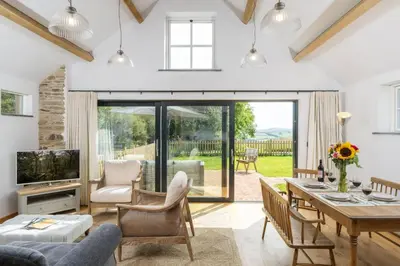 a living room with a table and chairs and a television at Skylark in Bodmin
