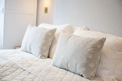 a white bed with four pillows on it at Skylark in Bodmin