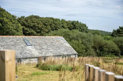 an old barn in a field with a fence at Skylark in Bodmin