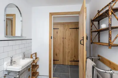 a bathroom with a sink and a wooden door at Skylark in Bodmin