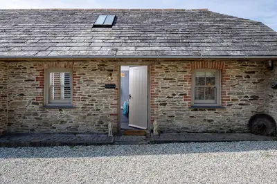 a brick cottage with a white door and two windows at Skylark in Bodmin