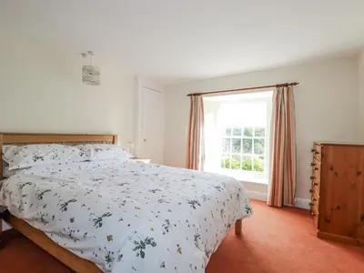a bedroom with a bed and a window at Tresarrett Manor in Bodmin