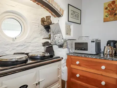 a kitchen with a stove and a microwave at Tresarrett Manor in Bodmin